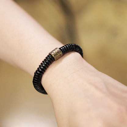 Bracelet calme en bois d'ébène et cuivre et laiton avec pierres de Bouddha 