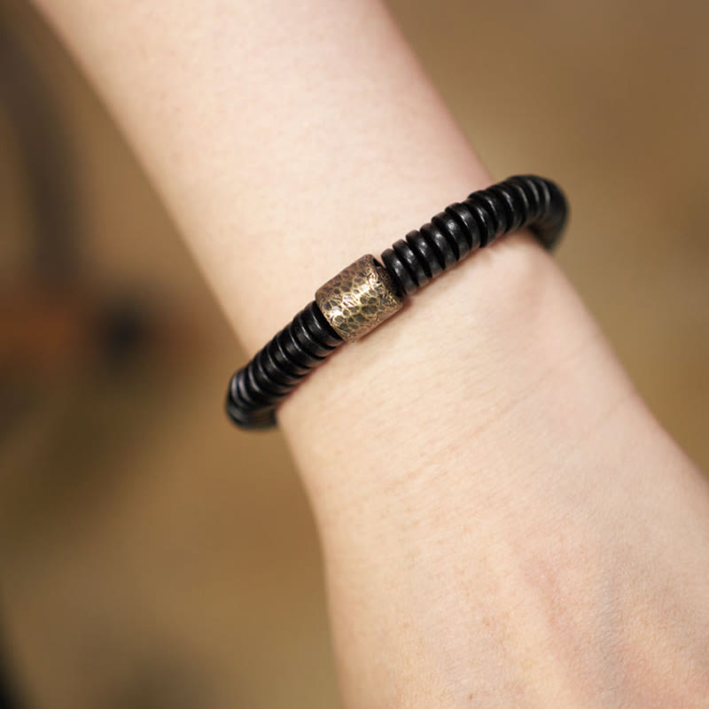 Bracelet calme en bois d'ébène et cuivre et laiton avec pierres de Bouddha 