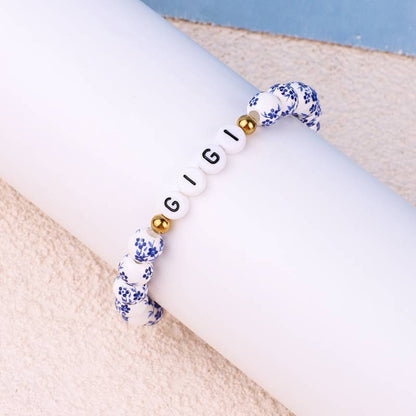 Bracelet personnalisé en porcelaine bleue avec perles florales et prénom