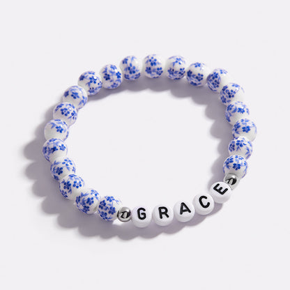 Bracelet personnalisé en porcelaine bleue avec perles florales et prénom